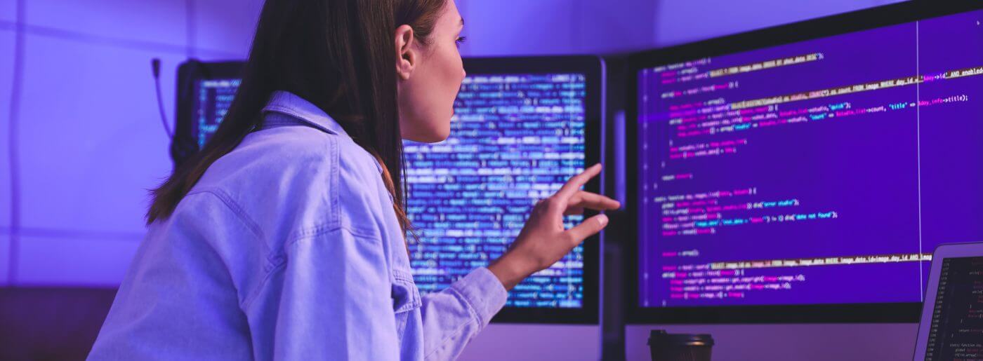 Woman pointing at computer while working with cloud and IOT provider