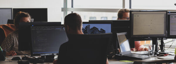 Developer looking at large computer screen working on observability overhaul
